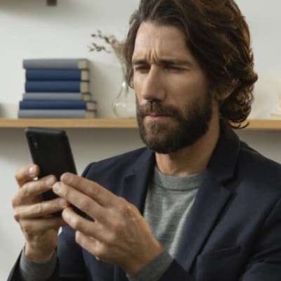 man holding phone close to face to read